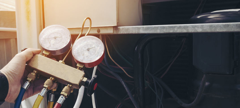 furnace technician hand holding up pressure gauges during maintenance visit